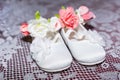 Pair of white baby shoes on pants and shirt at Christening Baptism Ceremony at church chapel