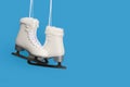 Pair of white figure ice skates on a blue background with space for copy Royalty Free Stock Photo