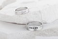 Pair of white gold wedding rings with diamonds on white textured background Royalty Free Stock Photo