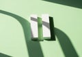 A pair of white and green blocks casting shadows on a light green background Royalty Free Stock Photo