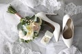 Pair of white high heel shoes  veil  rings and wedding bouquet on grey background  flat lay Royalty Free Stock Photo