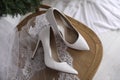 Pair of white high heel shoes, veil and wreath on wooden chair indoors, above view. Dressing for wedding Royalty Free Stock Photo