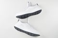 Pair of white male sneakers hanging on wall. Fashion stylish sport shoes, closeup