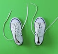 Pair of white old textile sneakers with untied laces Royalty Free Stock Photo
