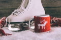 White skates with cup with knitted ornament and scarf