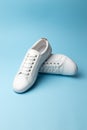 Pair of white sneakers on blue background. Fashion blog or magazine concept Royalty Free Stock Photo