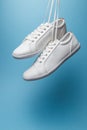 Pair of white sneakers on blue background. Fashion blog or magazine concept. Royalty Free Stock Photo