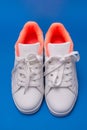 Pair of white sneakers isolated on blue background. Sport shoes. Royalty Free Stock Photo