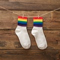 Pair of socks with rainbow edging on wooden background, idea for gift lgbt friends