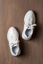 Pair of white tied laces sneakers on a brown background. New unisex chunky sole shoes for active lifestyle, fitness and sports. Royalty Free Stock Photo