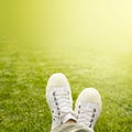 A pair of white trainers in the grass in the sunshine