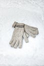 Pair of winter gloves lying in the snow Royalty Free Stock Photo