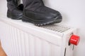 A pair of winter wet shoes drying on a central heating radiator