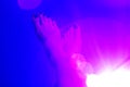 A pair of the woman`s foot on a dark blue color background with pink halo-effect