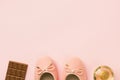 Pair of women`s girl`s ballerina pink pumps flats chocolate tablet perfume bottle on same color background. Female accessories f Royalty Free Stock Photo