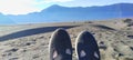 a pair of women's toe shoes against the backdrop of a vast black desert and mountains Royalty Free Stock Photo