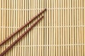 Pair of wooden chopsticks on bamboo mat, top view. Space for text Royalty Free Stock Photo