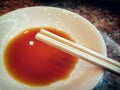 Pair of Wooden Chopsticks over a Dish of Soy Sauce. Royalty Free Stock Photo