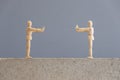 Pair of wooden human figures standing at a safe distance from each other