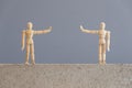 Pair of wooden human figures standing at a safe distance from each other