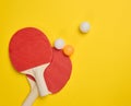 Pair of wooden tennis rackets for ping pong and plastic balls on a yellow background Royalty Free Stock Photo