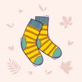 Pair of wool knitted striped socks. Hand drawn doodle illustration isolated on a light background with autumn leaves Royalty Free Stock Photo