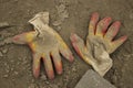 A pair of work gloves lying on the wet sand and a piece of gray paving slabs in the lower corner removed from above.