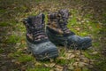 A pair of worn hiking boots on natural background. Dirty boots for hiking, fishing, traveling