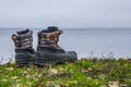 A pair of worn hiking boots on natural background. Dirty boots for hiking, fishing, traveling