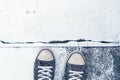 Pair of worn sneakers on concrete floor