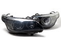 A pair of xenon headlights for a German auto - optical equipment with a lens and corrector inside on a white isolated background.