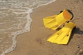 Pair of yellow flippers on sand near sea. Space for text Royalty Free Stock Photo