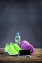 Pair of yellow green sport shoes towel water smart pone and headphones on wooden board. In the background forest or park trail. Royalty Free Stock Photo