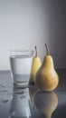 A pair of yellow pears and a glass of water on a reflective Royalty Free Stock Photo