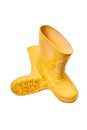 Pair of yellow rubber boots for kids isolated on white background three quarter view one over another sole side.