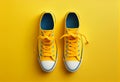 Pair of yellow trendy sneakers on yellow background, top view. Generative ai