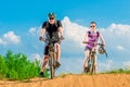 Pair of young cyclists on the hill against the sky Royalty Free Stock Photo
