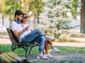 A pair of young people met in the park. Lovers are sitting on a bench Royalty Free Stock Photo