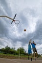 a pair of young players in the middle of a basketball court,