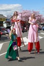 Two female stilt walkers in long pink dresses