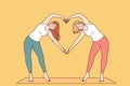 Paired yoga of two women doing pilates, standing on sports mat and making heart sign from hands Royalty Free Stock Photo