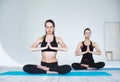 Paired yoga two women in lotus position in studio Royalty Free Stock Photo