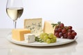 Pairing of Fine White Wine, Assorted Cheese Selection, and Fresh Grapes on a White Table
