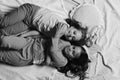 Pajama party and childhood concept. Girls lie on white and pink bed sheets hugging Royalty Free Stock Photo