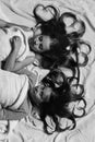 Pajama party and childhood concept. Girls lie on white and pink bed sheets Royalty Free Stock Photo