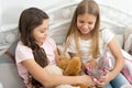 Pajamas party. Sisters sharing toys. Sisters best friends. Kids play toys in bed. Little girls spend time together Royalty Free Stock Photo