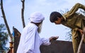 A Pakistani farmer showing wheat grains to working kid