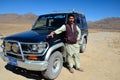 Pakistani jeep driver in salwar kameez poses with jeep at Deosai Plains Skardu Pakistan