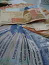 Pakistani rupees bank notes Rs. 500,1000 and 5000 on the table. Partially blurred computer background
