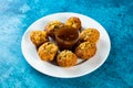 Pakistani spicy gol gappay, indian pani puri and bangali fuchka full of chaat masala with sour water in a dish isolated on marble